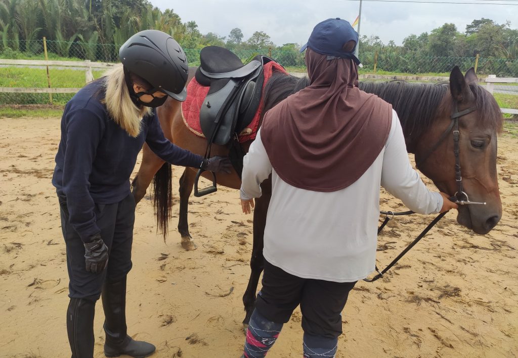 SEDEC Equine - student checking girth